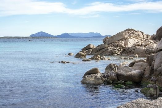 Green water and granite rock archipelago landscape on a beach in Costa Smeralda, Sardinia, Italy in March.