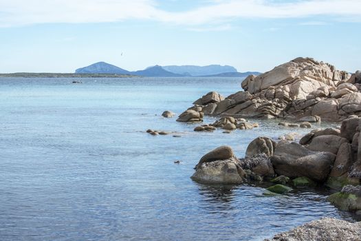 Green water and funny granite rock shapes on a beach in Costa Smeralda, Sardinia, Italy in March.