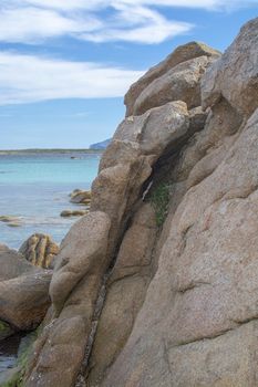 Green water and granite boulders on a beach in Costa Smeralda, Sardinia, Italy, vertical image.