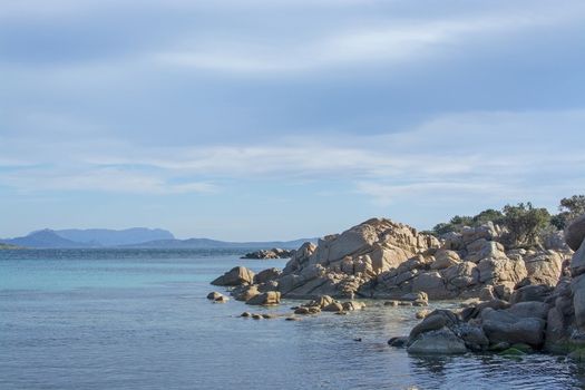 Green water and funny granite rock shapes on a beach in Costa Smeralda, Sardinia, Italy in March.