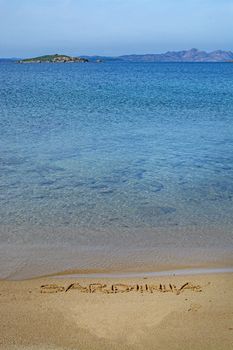 Sardinia word written in sand on a beach in Costa Smeralda, Sardinia, Italy.