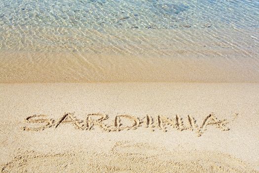 Sardinia word written in sand on a beach in Costa Smeralda, Sardinia, Italy.