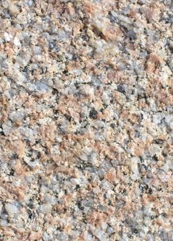 Granite surface texture closeup background shows large crystals of brown feldspar, quartz and black biotite.