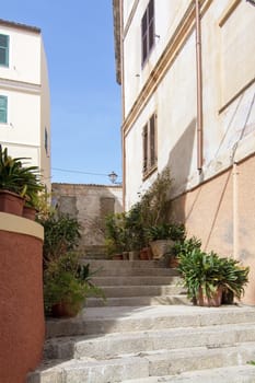 Stairs and buildings in the port area back streets on a sunny day in La Maddalena, Sardinia, Italy.