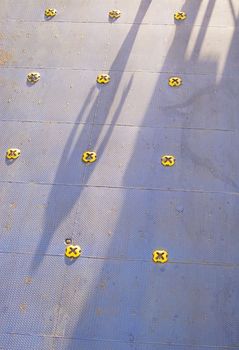 Colorful ferry car deck flooring in blue painted metal with yellow knobs.