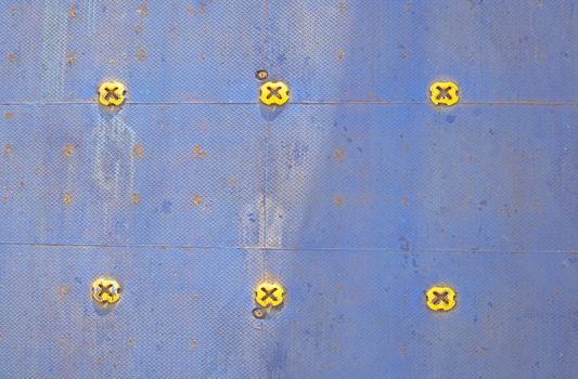 Colorful ferry car deck flooring in blue painted metal with yellow knobs.
