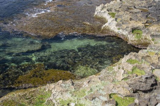 Clear transparent green water and limestone rocks closeup on a Majorca coast in the Mediterranean, Spain.