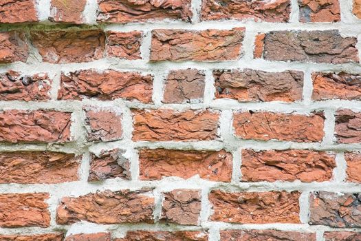 Old style brick wall with uneven bricks and white masonry background texture.