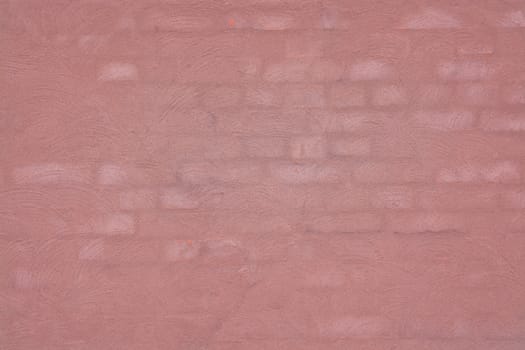 Washed brick wall background texture toned in Living Coral color