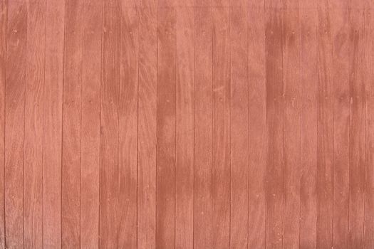 Brown weathered boardwalk planks background  toned in trend color Living Coral.