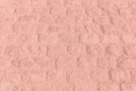 Old vintage cobble stone street background texture toned in trend color Living Coral.