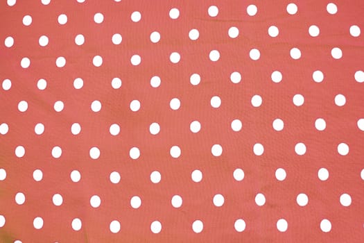Red and white polka dot printed fabric fun romantic background texture toned in Living Coral shades 