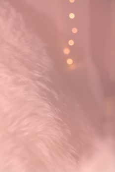 White lambswool fur and bokeh christmas lights winter concept background texture toned in Living Coral shades