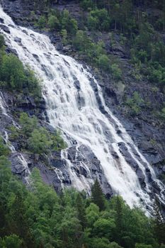 High waterfall in mountain forest near Rjukan, Hardanfervidda, Norway
