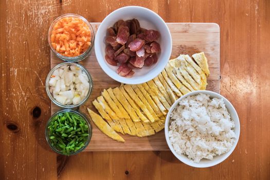 Ingredients for Fried Rice - Pork Sausages, Carrots, Beans, Rice and Omelette on Table