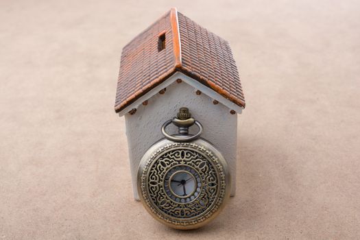 Little model house and a retro pocket watch