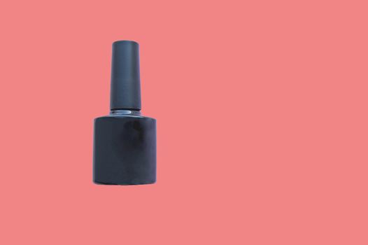 One black bottle of nail Polish on a background of living coral color, clipping, close-up, copy space.