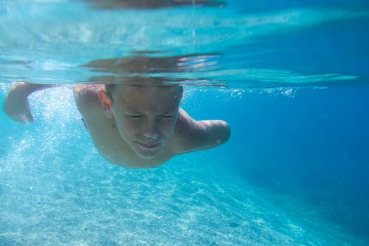 Boy diving on a breath hold swimming under water view