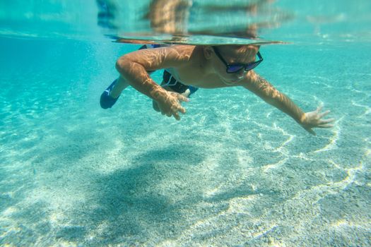 Boy diving on a breath hold swimming under water view