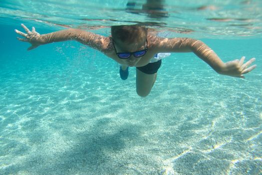 Boy diving on a breath hold swimming under water view