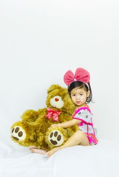 Portrait of cute asian little girl hugging her plush bear friend, indoor shot