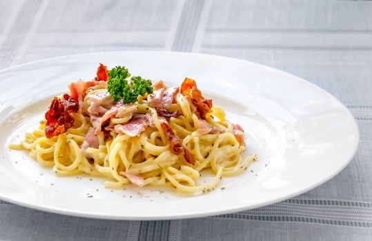 Spaghetti carbonara with bacon and cheese on white dish