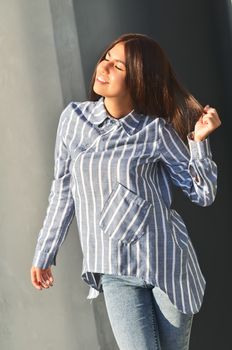 Young asian girl fashion posing near black the wall and is enjoing the sunny day