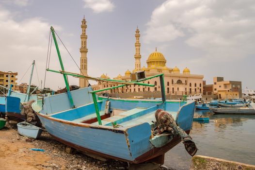 View of the Al Mina Masjid Mosque and its minarets in the city of hurghada from the old marina with its fishing boats