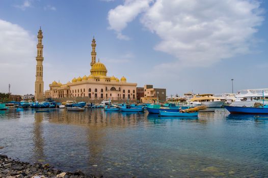 View of the Al Mina Masjid Mosque and its minarets in the city of hurghada from the old marina with its fishing boats