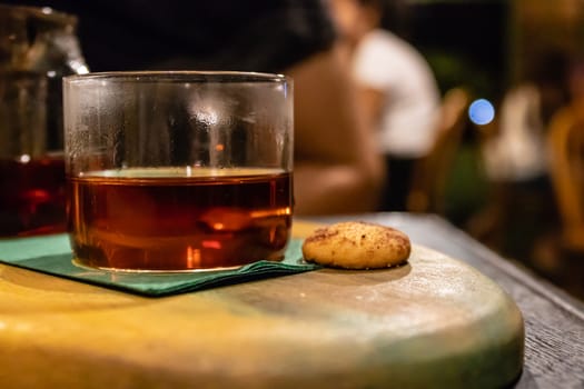 a closeup side view of a glass of tea and cookie. photo has taken from a cafe at izmir/turkey.