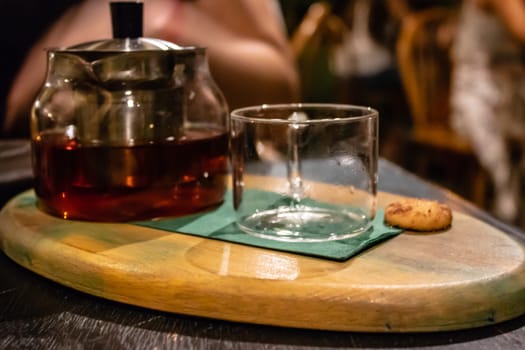 a side view of a good looking tea pot and glass with vivid colors.