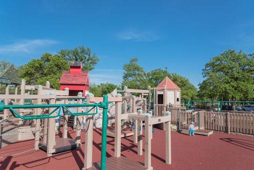 Kid playing at castle-inspired structure, elaborate wooden playground near Dallas, Texas, USA