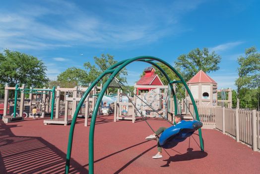 Kid playing at castle-inspired structure, elaborate wooden playground near Dallas, Texas, USA