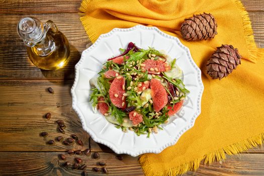 Plate with salad on a wooden desk and fabric