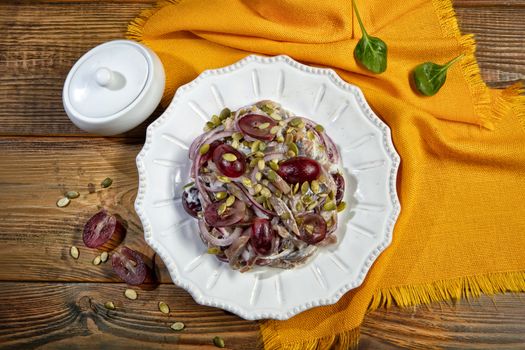 Plate with salad on a wooden desk and fabric
