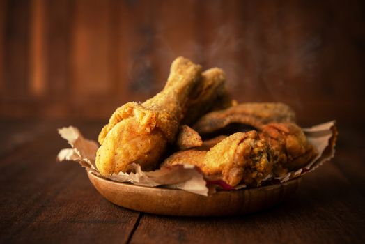 Plate of original recipe fried chickens, on dark wooden background.