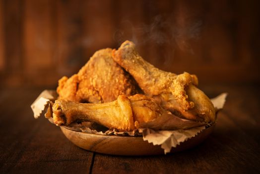 Plate of original recipe fried chickens, on dark wooden background.
