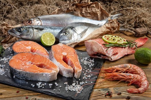 Red fish and limes on an old wooden desk