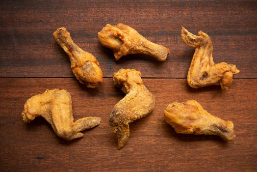 Top view flat lay original recipe fried chickens, on dark wooden background.