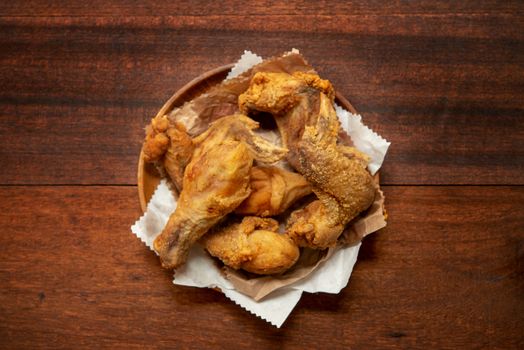 Top view flat lay plate of original recipe fried chickens, on dark wooden background.