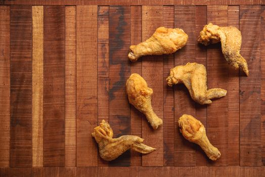 Top view flat lay original recipe fried chickens with copy space, on dark wooden background.