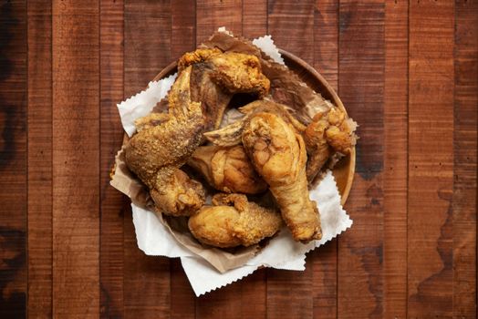 Top view flat lay plate of original recipe fried chickens, on dark wooden background.