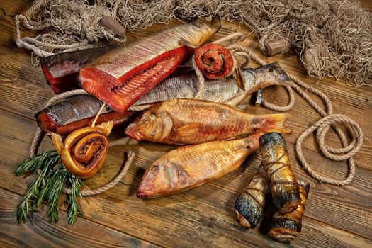 Different kinds of smoked fish and fushing net on a wooden desk