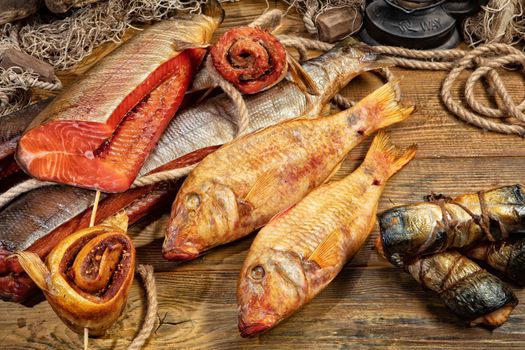 Different kinds of smoked fish and fushing net on a wooden desk