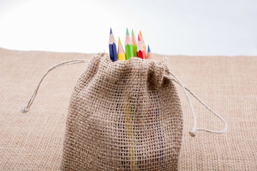 Color Pencils in a linen sack on canvas