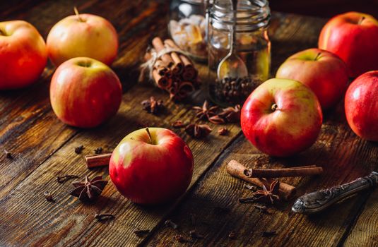 Red Apples with Different Christmas Spices on Wooden Table.