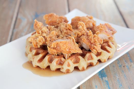 Fried crispy chicken waffle with maple syrup