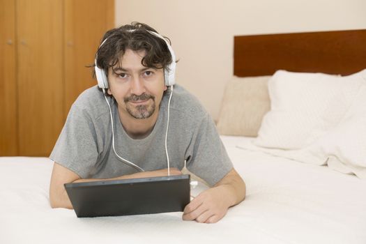 casual man working with a tablet pc in bed