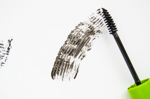 Black ink smear and green brush isolated on white.