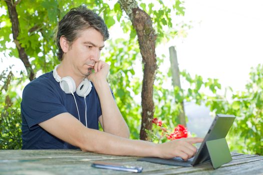 casual man working with a tablet pc, outdoor